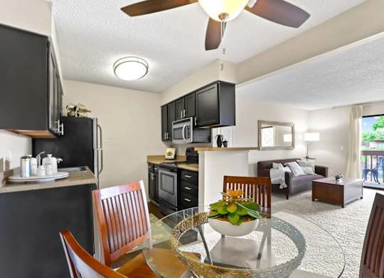 A modern kitchen with a dining table set for two.