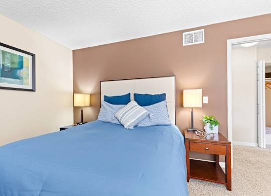 A bed with a blue cover and two blue pillows is in the image.