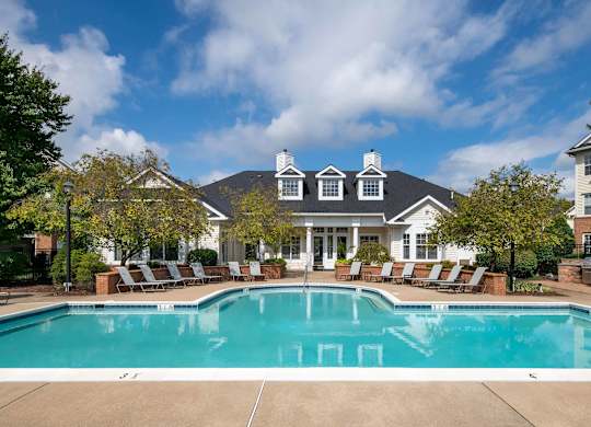 A large house with a pool in front.