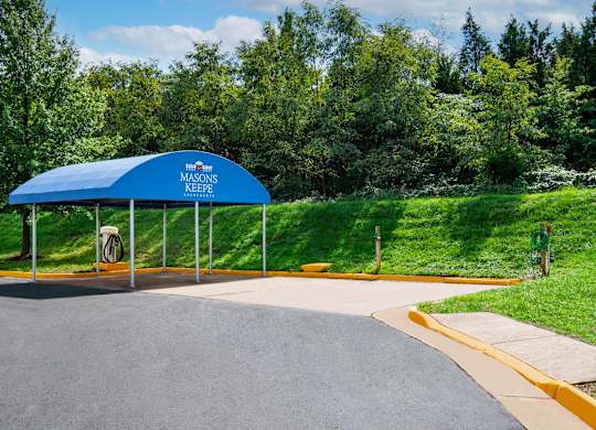 A blue canopy with a white sign that says "Masons Keefe" is in front of a grassy area.