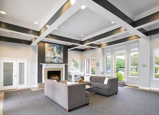 A living room with a grey couch and a fireplace.