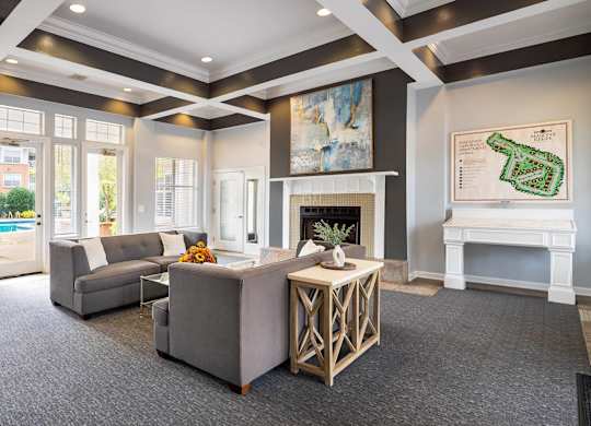 A living room with a grey couch and a white fireplace.