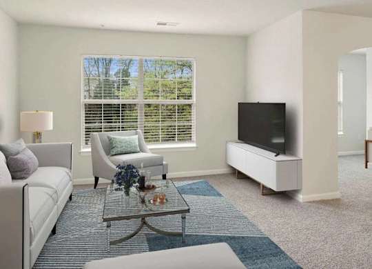 A living room with a white couch, a coffee table, and a television.