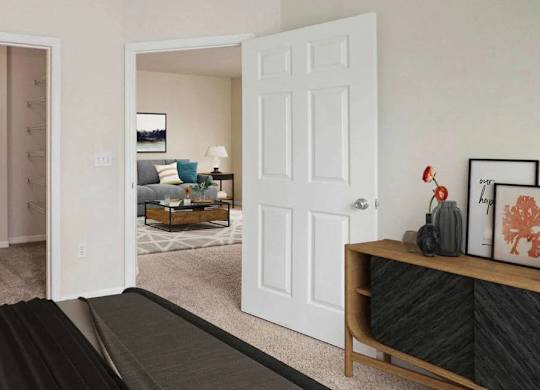 A living room with a grey couch and a painting on the wall.