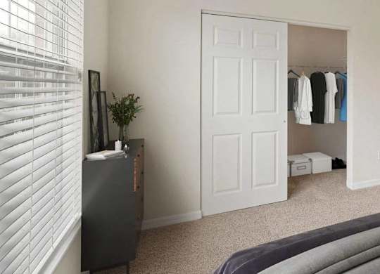 A bedroom with a bed, a dresser, and a painting on the wall.