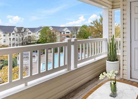 A balcony with a white door, a couch, and a potted plant.