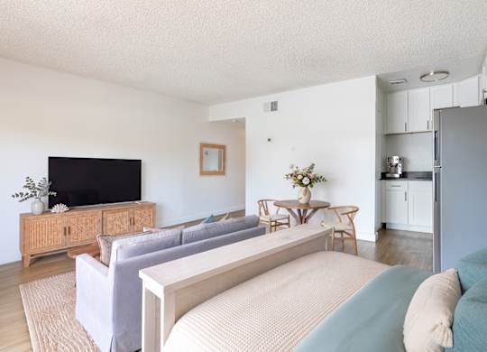 A living room with a grey couch and a wooden cabinet.