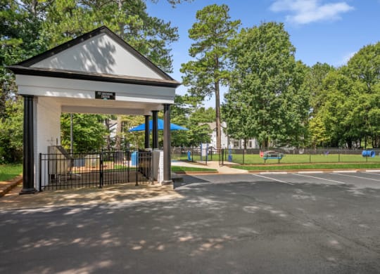 a bus stop with trees in the background and a parking lot in the foreground