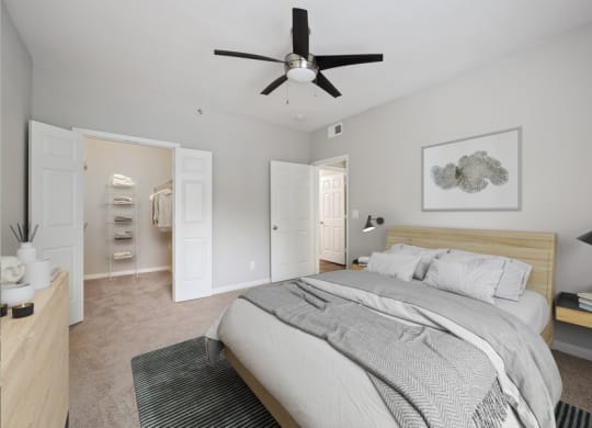 a bedroom with a large bed and a ceiling fan