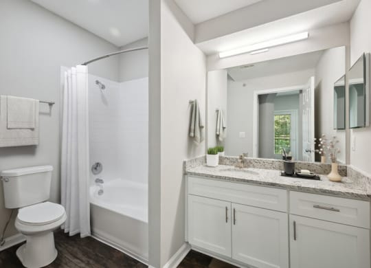 a bathroom with a large mirror and a toilet next to a bathtub with a shower curtain