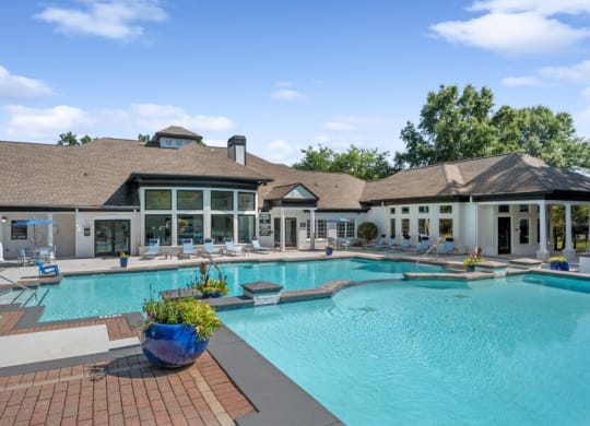 a swimming pool with lounge chairs and a building in the background