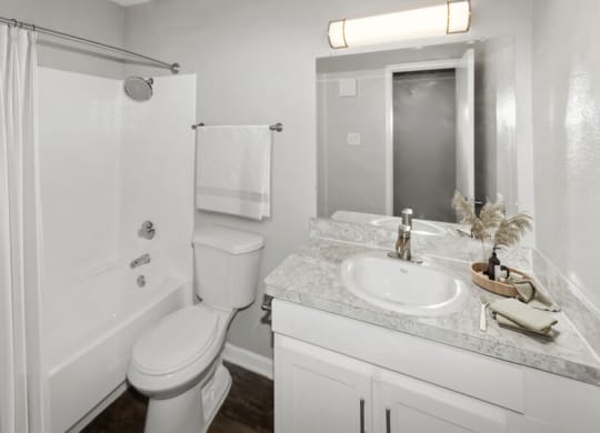 a white bathroom with a sink toilet and shower