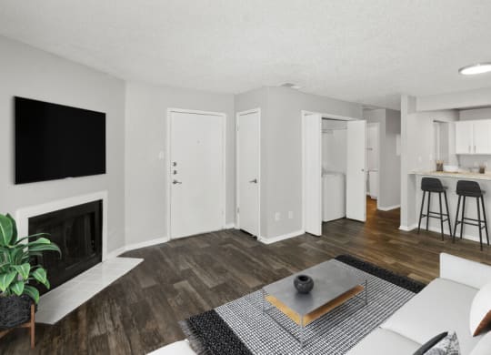 Model apartment living room with a fireplace and a kitchen