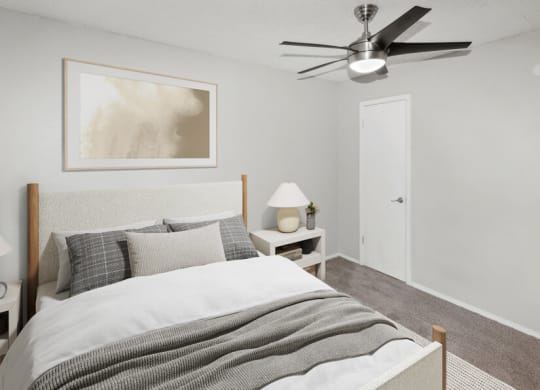 Model apartment bedroom with a bed and a ceiling fan