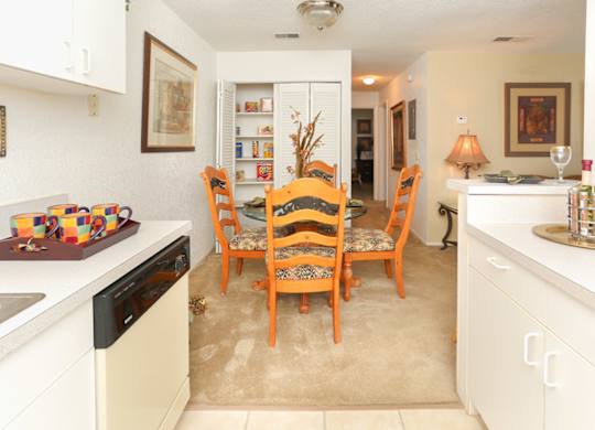 A kitchen with a table and chairs in the middle.