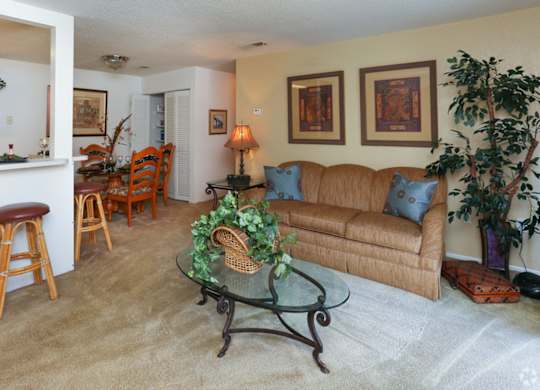 A living room with a couch, chairs, and a bar area.