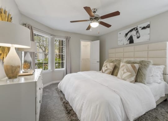 Model bedroom with large windows and ceiling fan