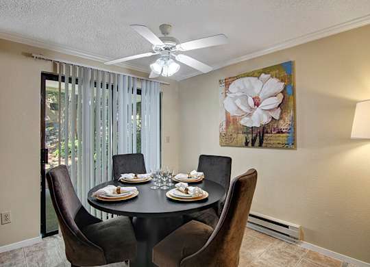 Model Dining Room and Patio Access at Ridge & Shores Apartments located in Federal Way, WA.