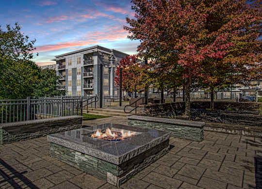 A fire pit sits in the middle of a paved courtyard.