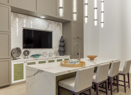 a kitchen with a large center island with a breakfast bar and a flat screen tv