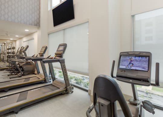 a room filled with cardio equipment and a flat screen tv
