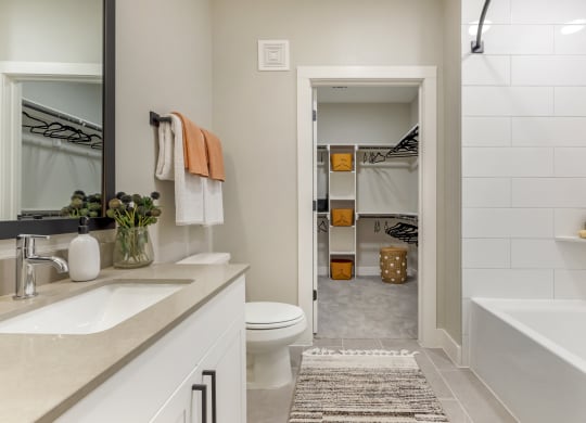 a bathroom with a tub and a toilet next to a sink