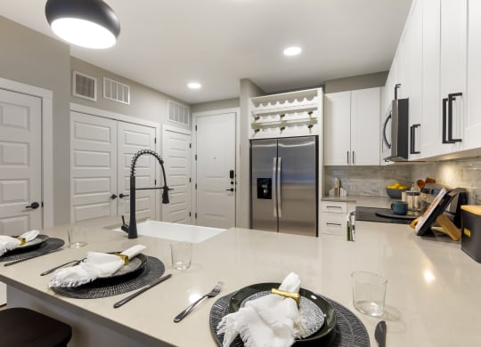 a kitchen with white cabinetry and a large center island with a white countertop