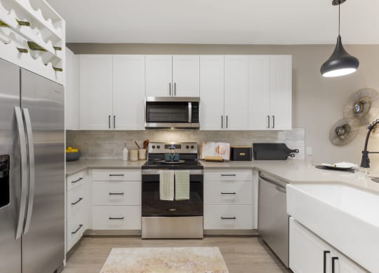 a kitchen with white cabinets and stainless steel appliances