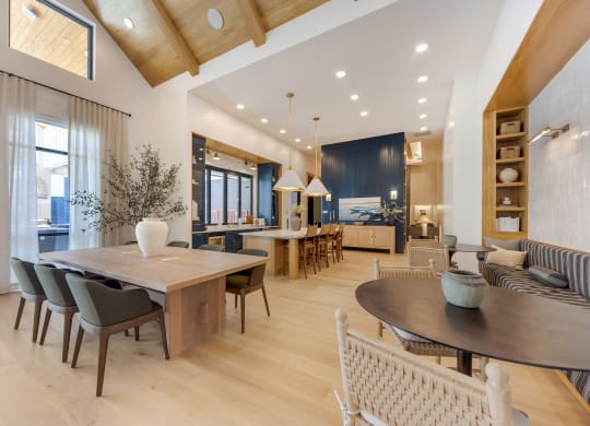 a dining area with a wooden table and chairs and a living room with a kitchen