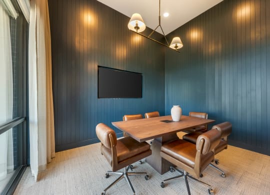 a conference room with a table and chairs and a tv