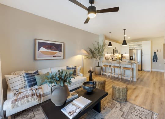a living room with a couch and a table in front of a kitchen