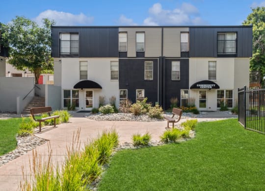 a courtyard with two benches and a bench in front of the apartments