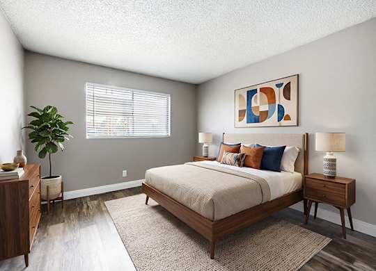 Model Bedroom with Wood-Style Flooring at Bridges at Tropicana Apartments located in Las Vegas, Nevada.