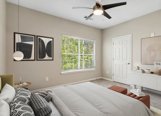 Model apartment bedroom with a large bed and a ceiling fan