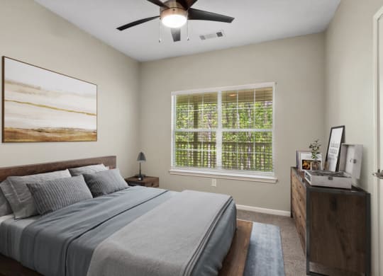 Model apartment bedroom with a bed and a ceiling fan