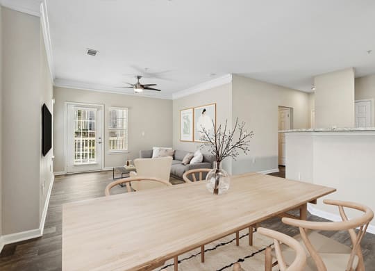 a living room and dining room with a wooden table
