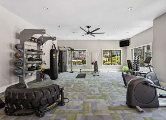 gym with plenty of exercise equipment and windows