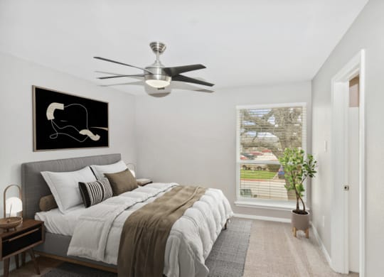 a bedroom with a bed and a ceiling fan