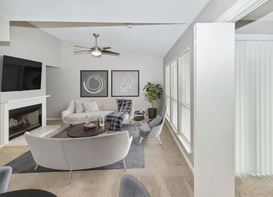 a living room with white furniture and a fireplace