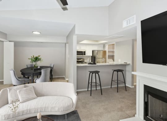 a living room with a couch and a kitchen with a bar