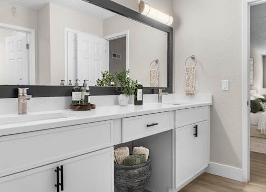 A bathroom with two sinks and a large mirror. at Riverchase Landing, Alabama