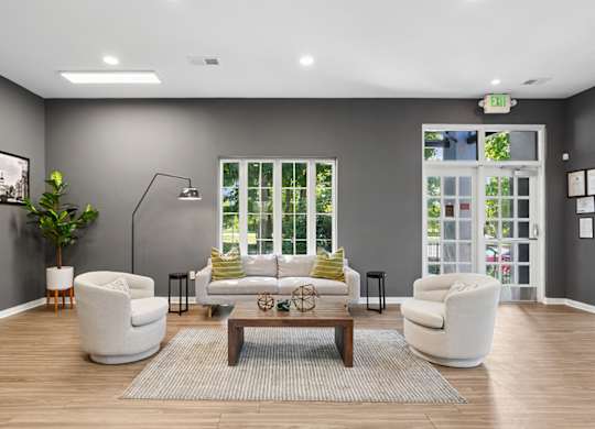 A living room with a grey wall and a large window.