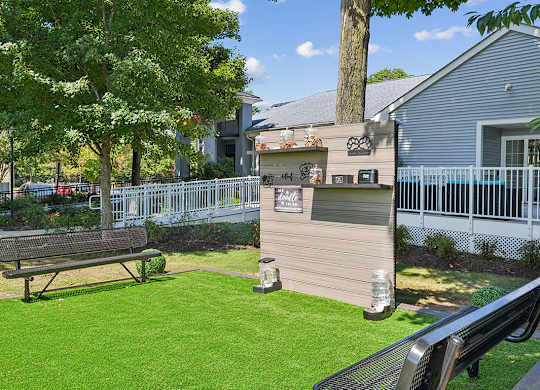 A park with a bench and a fence.