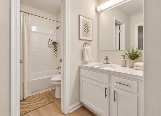 Bright bathroom with white vanity and tub shower combo at The Courts at Fair Oaks Apartments, Fairfax