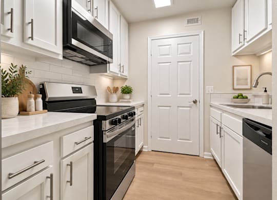 Galley kitchen with white cabinets and skylight at The Courts at Fair Oaks Apartments, Fairfax, VA