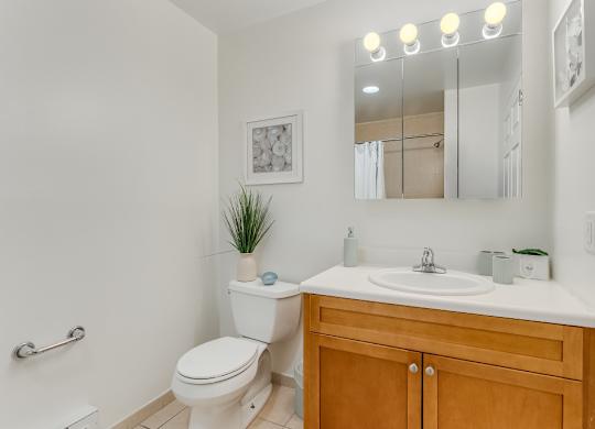 Modern bathroom with wood vanity and white countertop at Pier Village Apartments, Long Branch, NJ 7740