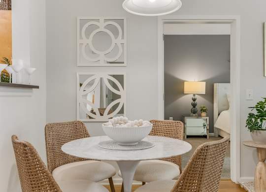 Dining area with round table and woven chairs at Pier Village Apartments, New Jersey, 7740