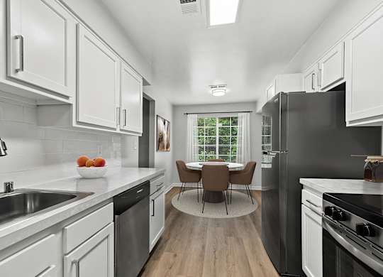 A modern kitchen with a dining table and chairs.