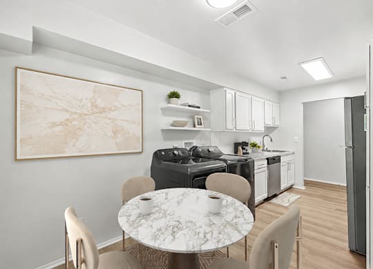 A modern kitchen with a marble table and chairs.