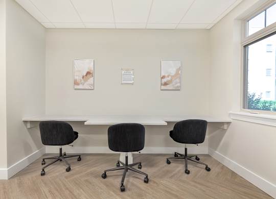 a conference room with a table and chairs and two paintings on the wall at Copper and Quarry Village, Maryland, 21209